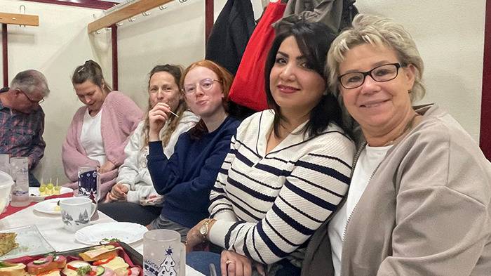 6 Personen sitzen am Tisch in gemütlicher Runde