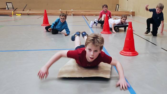 Personen auf dem Hallenboden bei der Disziplin Skeleton