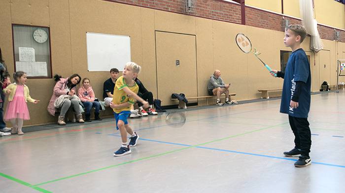zwei Kinder am Badminton spielen