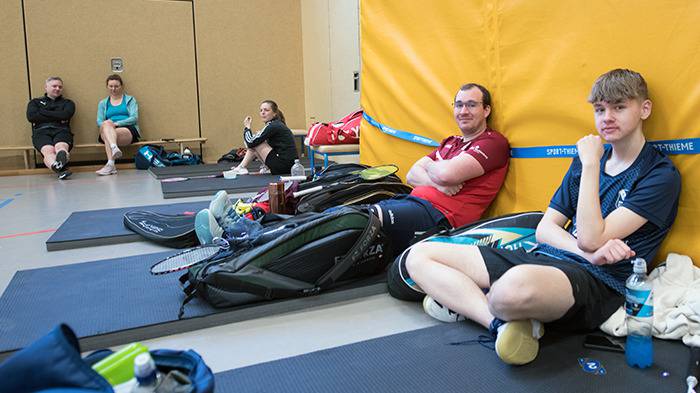 3 Personen auf den Matten und zwei auf der Bank