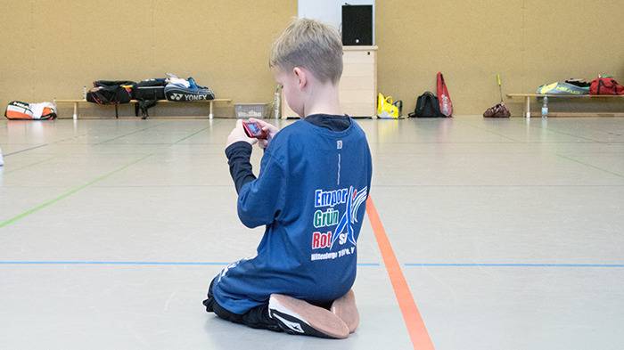 Jugendlicher auf dem Boden mit Fotoapparat