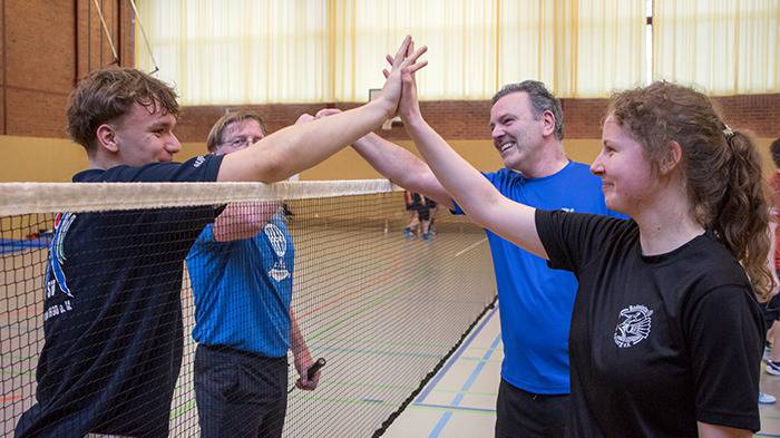 vier Personen nach dem Spiel klatschen ab