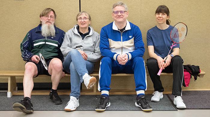 vier Personen auf der Bank in der Halle