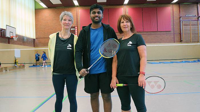 3 Personen posieren vor der Kamera