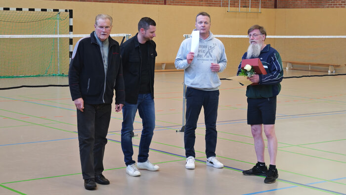 vier Personen in der Halle vor der Gruppe bei Ansprache