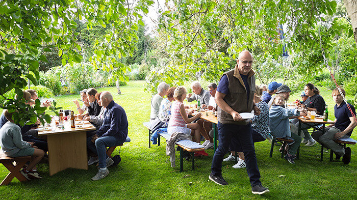 größte Teil der Anwesenden am Tisch unter einen Baum