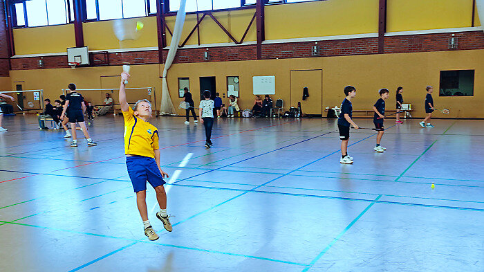 ein Spieler springt um den Federball zu bekommen